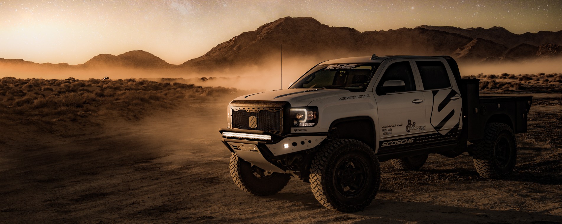 Truck on desert trail kicking up dirt