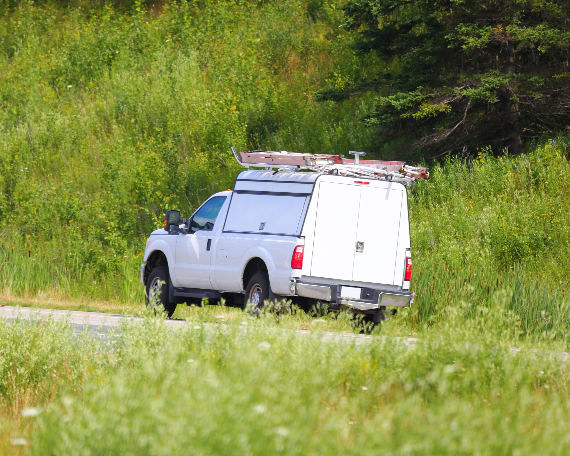 White work truck driving in field